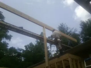 Carpenter setting a ridge beam over a new addition frame — Ice Dam Removal by Roofing Brothers in East Pembroke