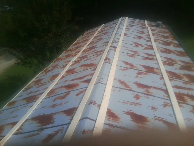 Rusted metal roof panels with new wood purlins before replacement — Storm Damage Roof Repair in East Pembroke by Roofing Brothers