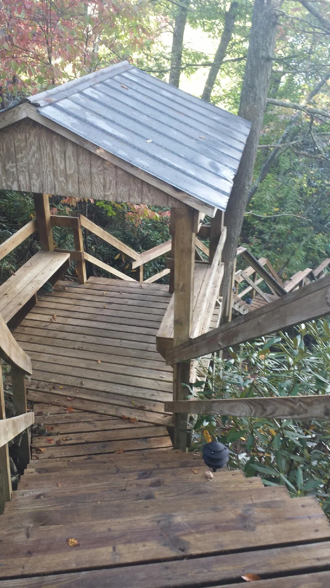 Metal roofed shelter over wooden steps on a wooded walkway — Skylight Repair & Installation work by our crew in East Pembroke