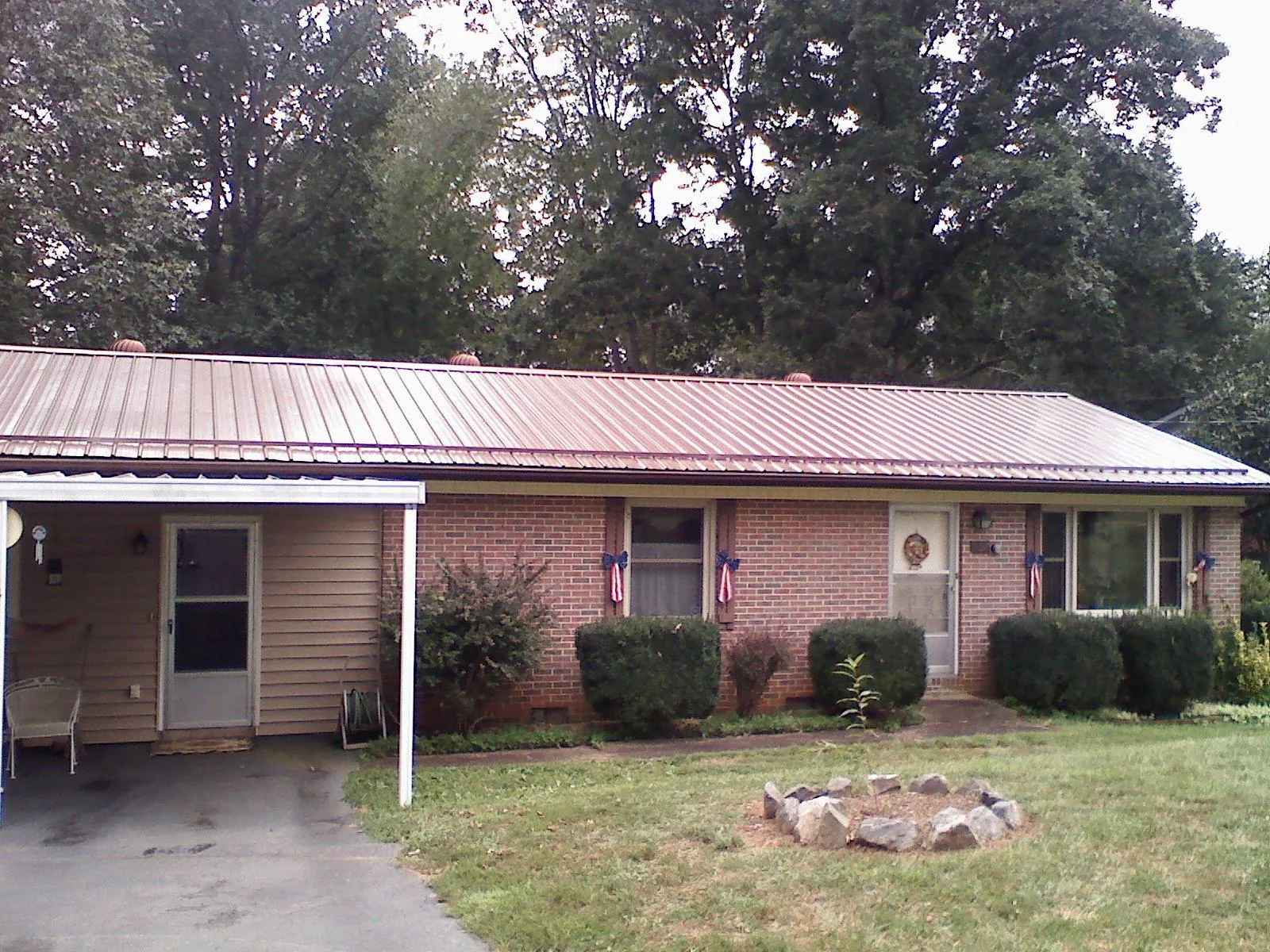 Bronze metal roof and carport on a brick ranch home — Roof Repair work by our crew in East Pembroke